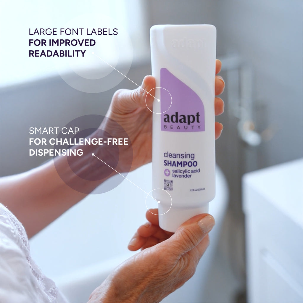 Hand holding a bottle of 'adapt beauty' cleansing shampoo with text highlighting features like large fonts and challenge-free dispensing