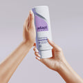Person holding a bottle of Adapt shampoo against a plain background