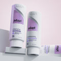 Bottles of adapt shampoo and conditioner with describing clean ingredients and accessible haircare