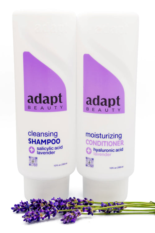 Adapt Beauty Shampoo and Conditioner bottles shown with lavender sprigs
